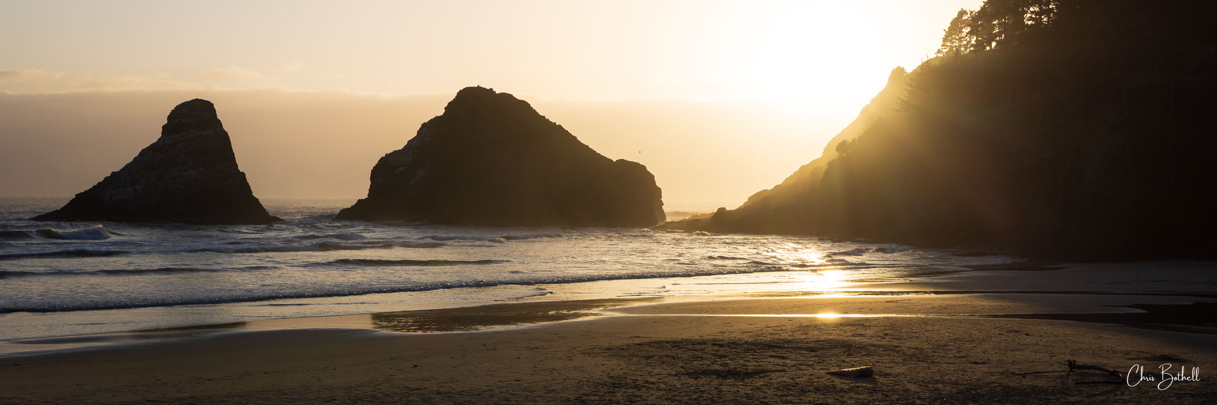 Beach Glow A gentle haze softens the distant waters as golden light washes over the rugged silhouette of the Oregon coast.