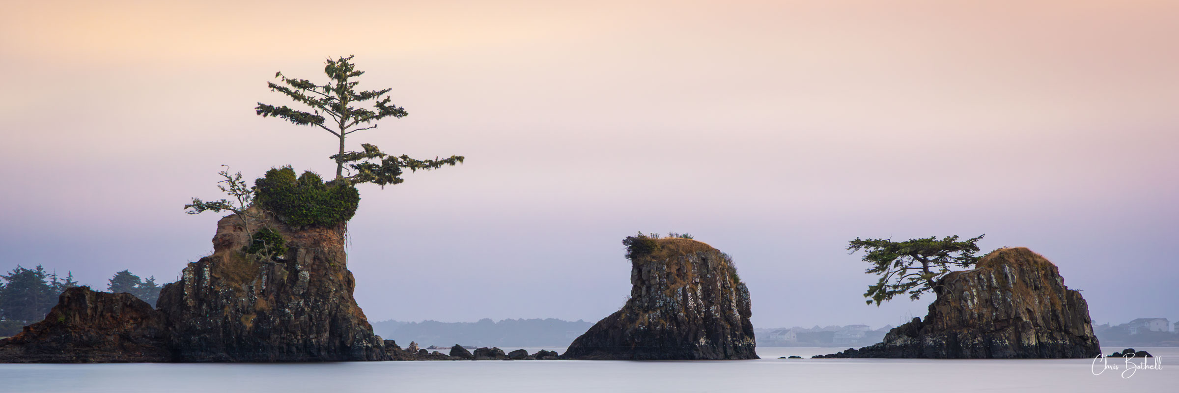 Three Amigos Three rocks stand weathered and sculpted from time in the bay as the setting sun paints the sky with color.