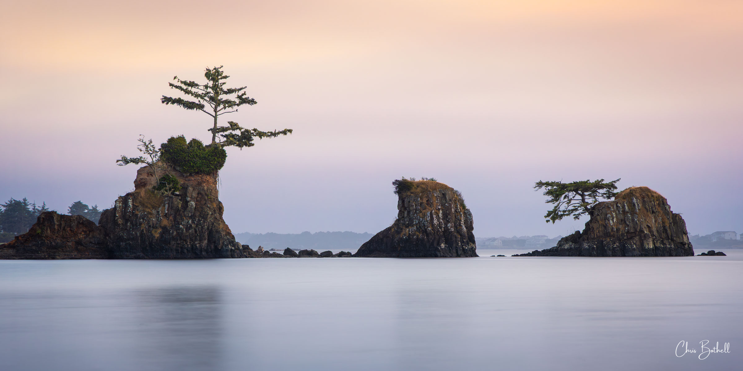 Three Amigos Three rocks stand weathered and sculpted from time in the bay as the setting sun paints the sky with color.